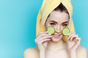 portrait-young-beautiful-woman-with-healthy-skin-holds-two-piece-cucumber-near-face